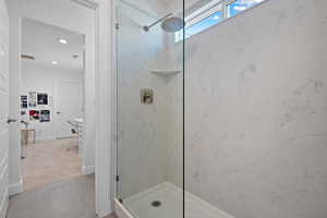 Bathroom featuring tile patterned floors, recessed lighting, a marble finish shower, baseboards, and vanity