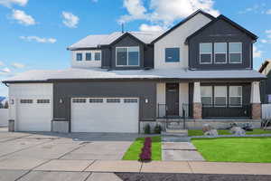 View of front of property featuring concrete driveway, a garage, board and batten siding, and a front lawn