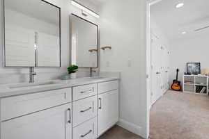 Bathroom with a sink, baseboards, recessed lighting, and double vanity