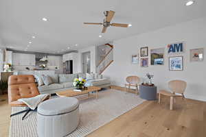 Living room with recessed lighting, stairway, light wood-style floors, and a ceiling fan