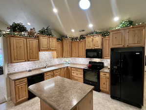 Kitchen with visible vents, a kitchen island, lofted ceiling, a sink, and black appliances
