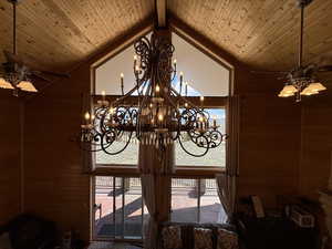 Detailed view of ceiling fan, wood walls, a chandelier, and wooden ceiling