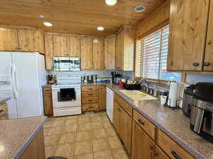Kitchen with white appliances, a sink, wood ceiling, recessed lighting, and light tile patterned floors