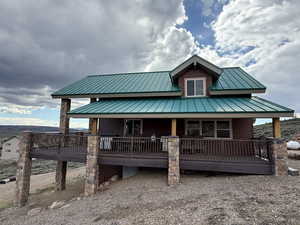 View of front facade with a porch, metal roof, and a standing seam roof