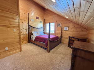 Bedroom with lofted ceiling, carpet flooring, wood walls, recessed lighting, and wood ceiling
