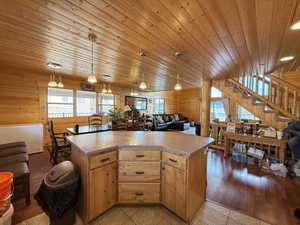 Kitchen featuring wooden ceiling, plenty of natural light, open floor plan, wood walls, and a kitchen island