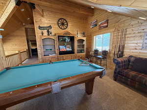 Game room featuring wooden walls, carpet, wooden ceiling, and pool table