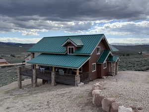 Rear view of house featuring metal roof and a deck with mountain view