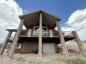 Back of property with a garage and a wooden deck