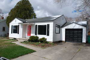 View of front of home with a garage, board and batten siding, roof with shingles, and driveway