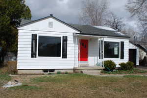 Bungalow with roof with shingles and a front yard