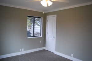 Spare room with baseboards, ceiling fan, and dark carpet