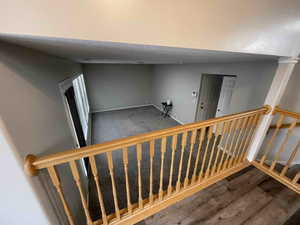 Stairway with wood finished floors, baseboards, and a textured ceiling