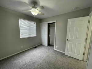 Unfurnished bedroom with visible vents, baseboards, ceiling fan, a closet, and carpet flooring