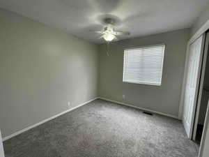 Unfurnished bedroom featuring new carpet, visible vents, and baseboards