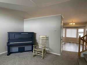 Living area featuring baseboards, new carpet floors, lofted ceiling