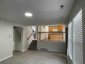 family room featuring visible vents, stairway, baseboards, and carpet