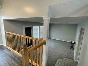 Staircase with carpet, baseboards, and a textured ceiling