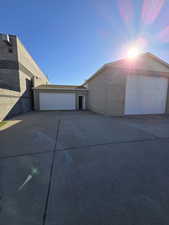 View of property exterior featuring brick siding, driveway, and a garage