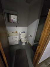 Bathroom with toilet, vanity, and baseboards