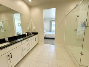 Master bathroom in Master Bedroom ensuite bath, tile patterned flooring, double vanity, and tiled, glass covered shower
