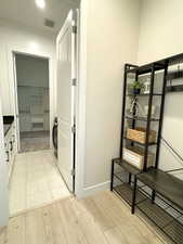 Mud Room walk to laundry room, connected to Master Bedroom walk in closet featuring light wood-style floors, visible vents, and baseboards