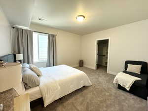 Bedroom 5 featuring a spacious closet, carpet, visible vents, and baseboards