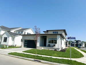 View of front of home with a garage, a porch, concrete driveway, and a front yard
