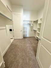 Master bedroom Spacious walk in closet featuring carpet flooring