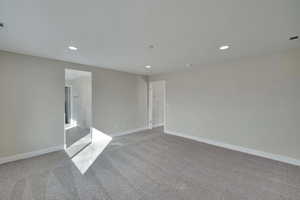 Empty room featuring recessed lighting, baseboards, and carpet flooring
