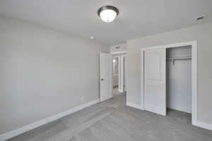 Unfurnished bedroom featuring a closet, visible vents, baseboards, and carpet