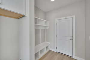 Mudroom featuring light wood-style flooring and baseboards