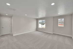 Unfurnished room with light carpet, visible vents, and baseboards