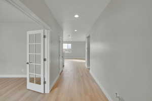Hallway with recessed lighting, baseboards, and light wood finished floors