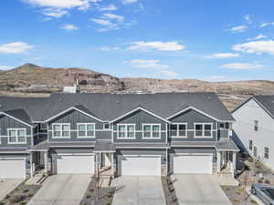 Multi unit property featuring stone siding, board and batten siding, and a garage