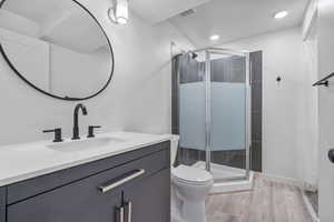Basement bathroom with glass shower stall and walk in closet