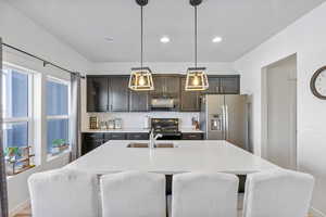 Kitchen with light quartz countertops and dark cabinets