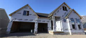 Property under construction featuring gravel driveway and a garage