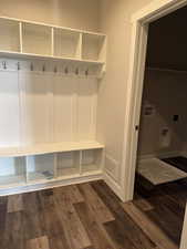 Mudroom featuring dark wood-type flooring, off of attached garage.
