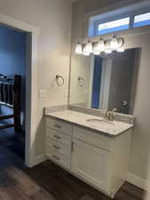 Bathroom featuring vanity, baseboards, and wood finished floors
