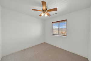 Unfurnished room featuring a ceiling fan, baseboards, visible vents, and carpet floors