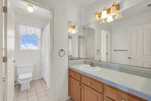 Full bathroom featuring visible vents, toilet, an inviting chandelier, tile patterned flooring, and vanity