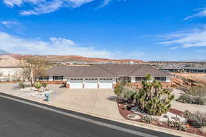 Single story home with concrete driveway, a tiled roof, a garage, and a mountain view