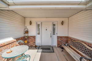 View of exterior entry with brick siding