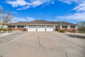 Single story home with brick siding, concrete driveway, an attached garage, and a tile roof