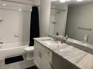 Full bathroom with vanity, toilet, shower / bath combo, and tile patterned floors