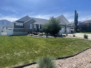 Craftsman-style home featuring board and batten siding, stone siding, driveway, and an attached garage