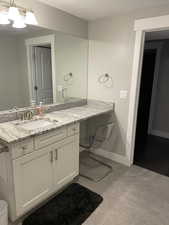Bathroom with vanity, baseboards, and a chandelier
