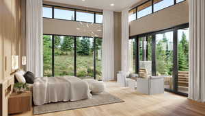 Bedroom featuring access to exterior, a towering ceiling, and wood finished floors