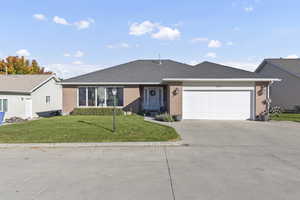 Single story home with driveway, a front yard, roof with shingles, and brick siding
